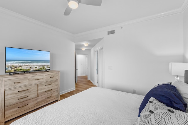 bedroom featuring ceiling fan, crown molding, and light hardwood / wood-style flooring