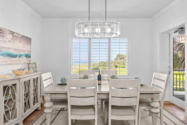 dining space with light wood-type flooring, ornamental molding, and a wealth of natural light