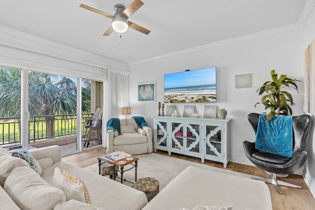 living room with ornamental molding, ceiling fan, and light hardwood / wood-style floors