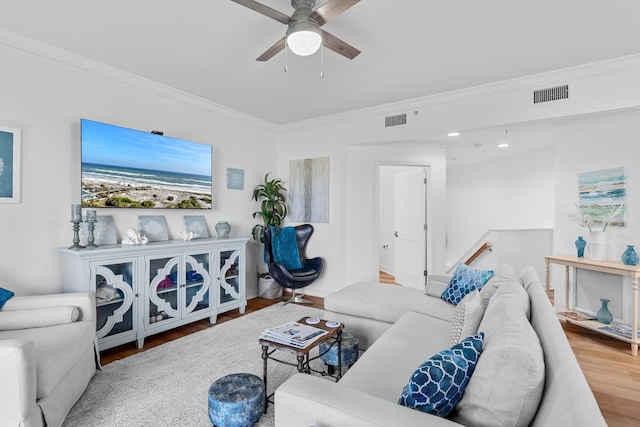 living room featuring ceiling fan, ornamental molding, and hardwood / wood-style floors