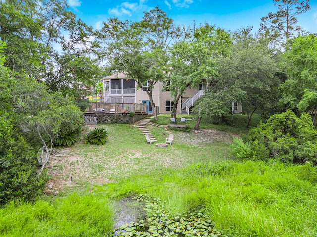 view of yard featuring a sunroom and a deck