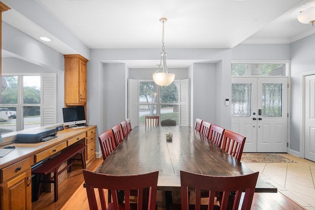 dining room with light wood-type flooring, french doors, and ornamental molding