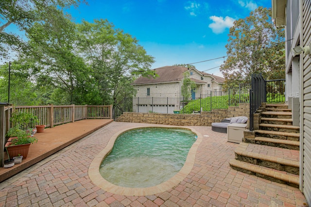 view of swimming pool featuring a wooden deck and a patio