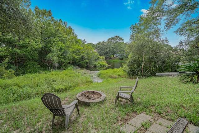 view of yard featuring a water view and an outdoor fire pit