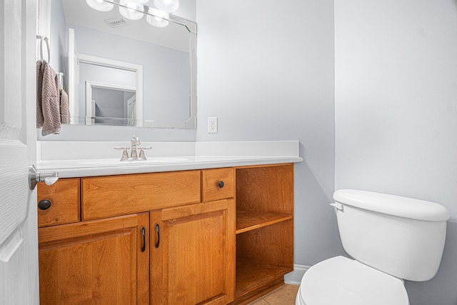 bathroom with tile patterned flooring, vanity, and toilet