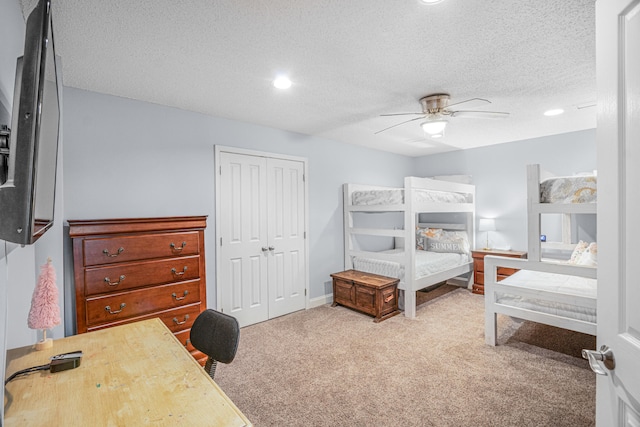 carpeted bedroom with a textured ceiling, ceiling fan, and a closet