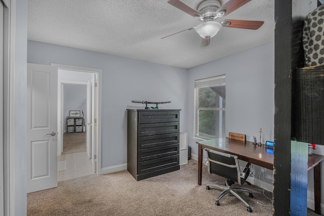 carpeted office space with a textured ceiling and ceiling fan