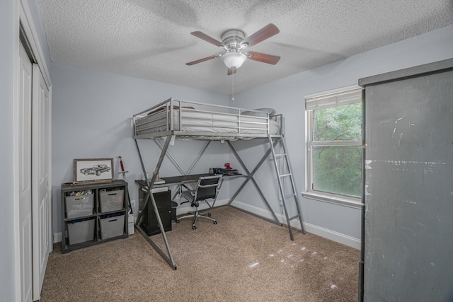 bedroom featuring a closet, a textured ceiling, ceiling fan, and carpet flooring