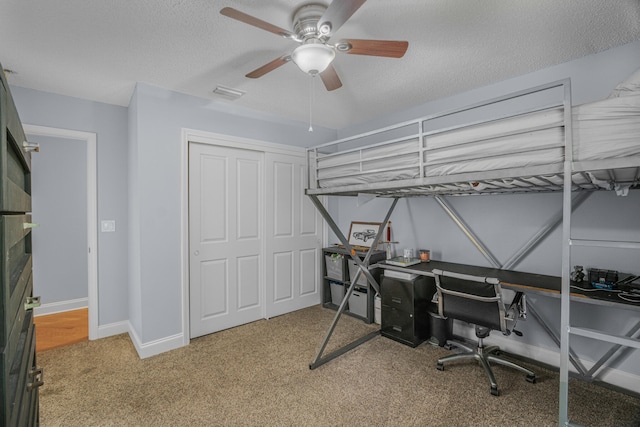 bedroom featuring carpet flooring, a closet, ceiling fan, and a textured ceiling