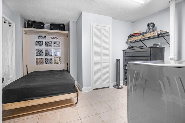 tiled bedroom with a textured ceiling and a closet