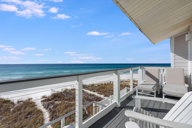 balcony featuring a view of the beach and a water view