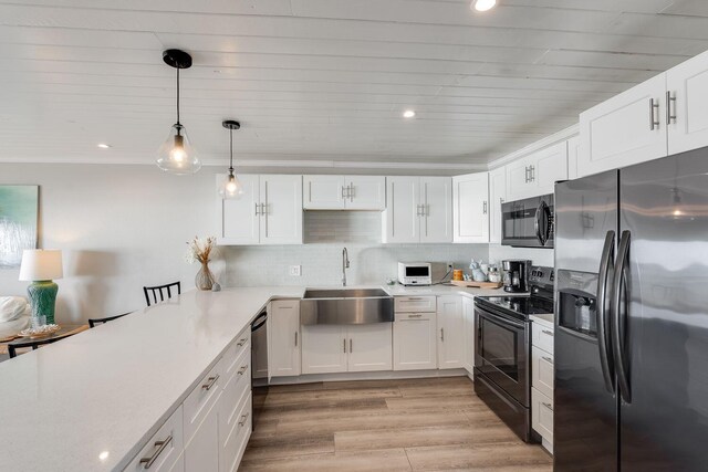 kitchen featuring light wood-type flooring, black appliances, sink, and white cabinets