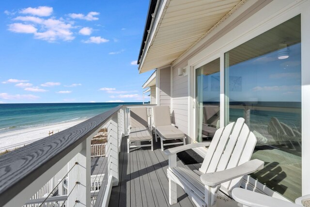 balcony with a water view and a view of the beach