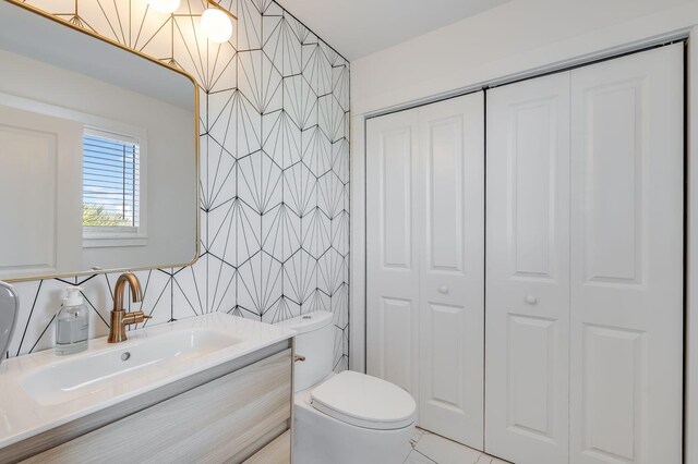 bathroom featuring tile walls, vanity, and toilet