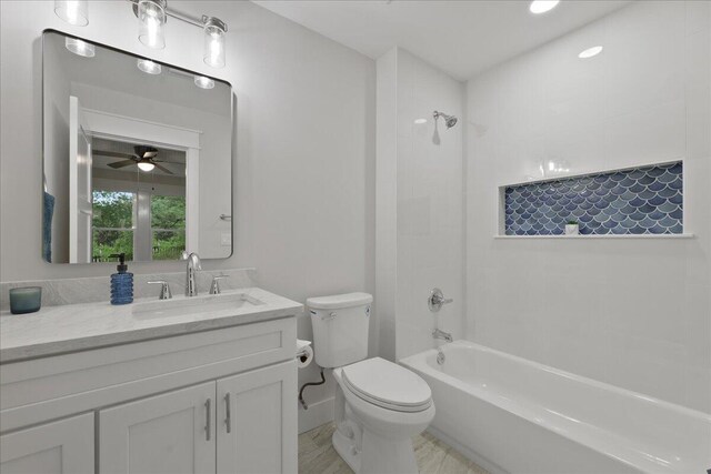 full bathroom featuring ceiling fan, toilet, vanity, and washtub / shower combination