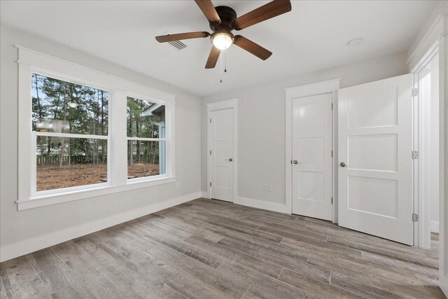 unfurnished bedroom with ceiling fan and light hardwood / wood-style flooring