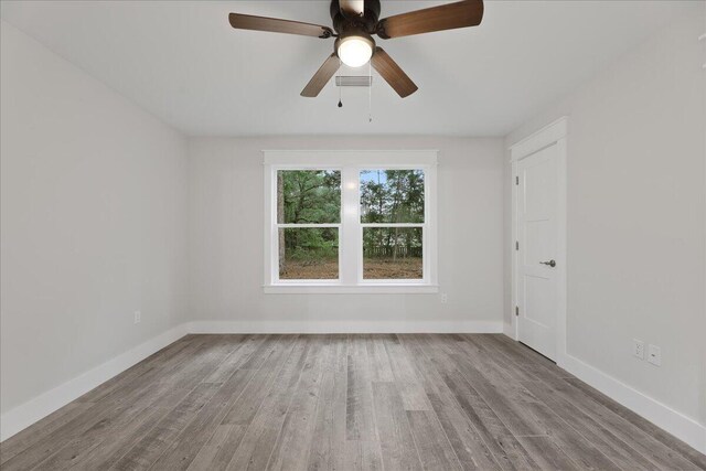 empty room with ceiling fan and light hardwood / wood-style floors