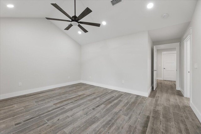 empty room with hardwood / wood-style flooring, vaulted ceiling, and ceiling fan