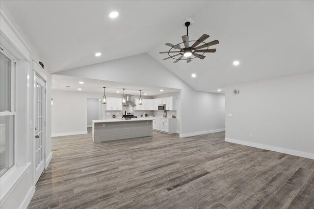 unfurnished living room featuring hardwood / wood-style flooring, high vaulted ceiling, and ceiling fan