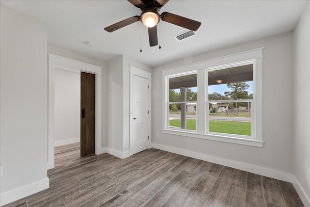 unfurnished bedroom with ceiling fan and wood-type flooring