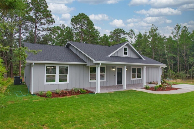 view of front of home featuring a porch, central air condition unit, and a front yard