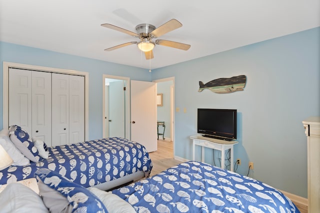 bedroom featuring ceiling fan, a closet, and light wood-type flooring