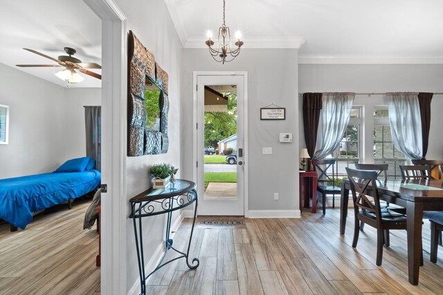 foyer featuring ceiling fan with notable chandelier, crown molding, and light hardwood / wood-style flooring