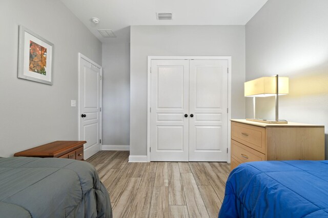 bedroom with light hardwood / wood-style flooring and a closet