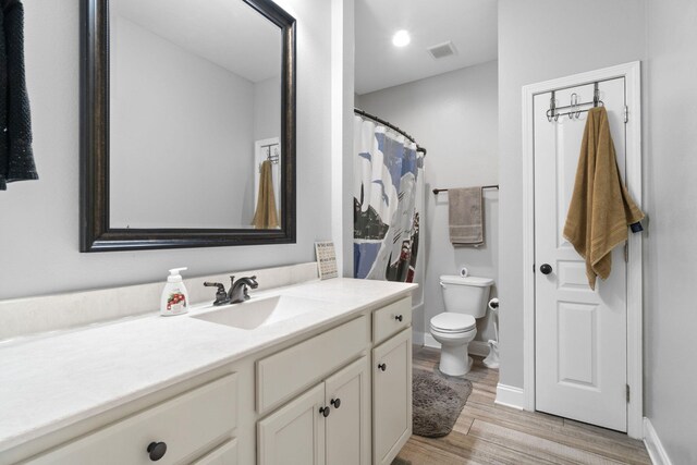 bathroom featuring vanity, toilet, and wood-type flooring