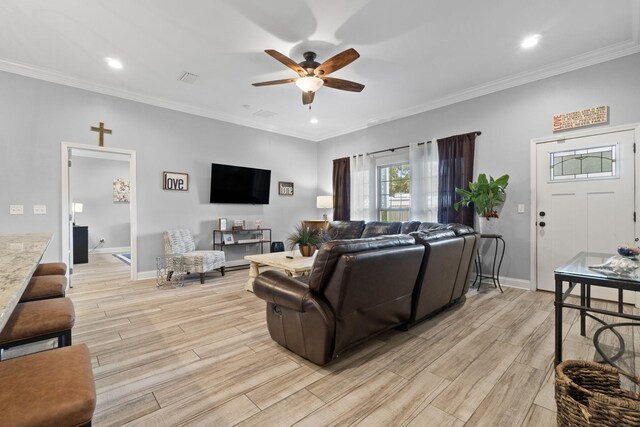 living room featuring ceiling fan, light hardwood / wood-style floors, and crown molding