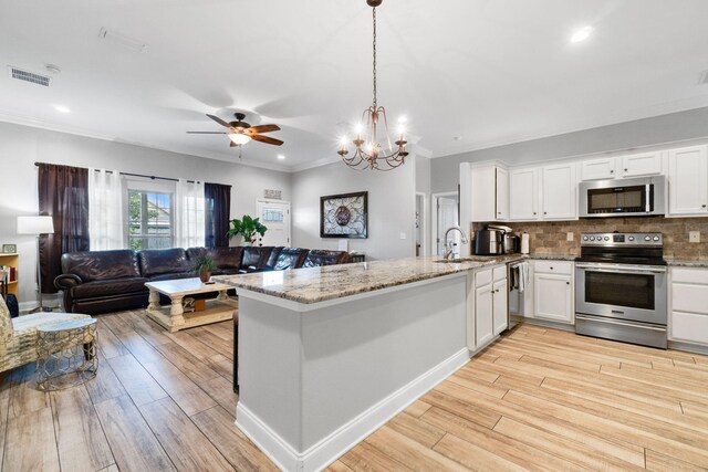 kitchen with light wood-type flooring, appliances with stainless steel finishes, white cabinetry, and kitchen peninsula