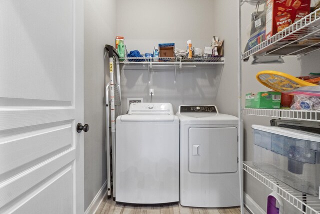 laundry room featuring light hardwood / wood-style floors and washer and dryer