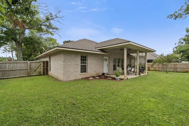 rear view of house with a lawn and a patio