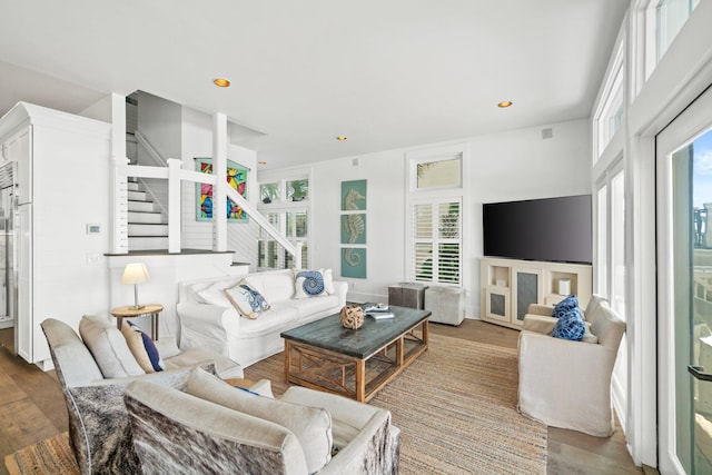 living room featuring light wood-type flooring and a healthy amount of sunlight