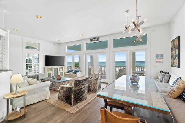 interior space featuring a fireplace, french doors, hardwood / wood-style flooring, and a chandelier