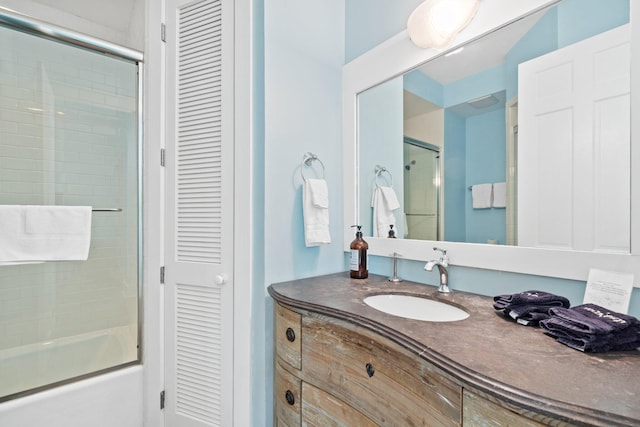 bathroom with shower / bath combination with glass door and vanity