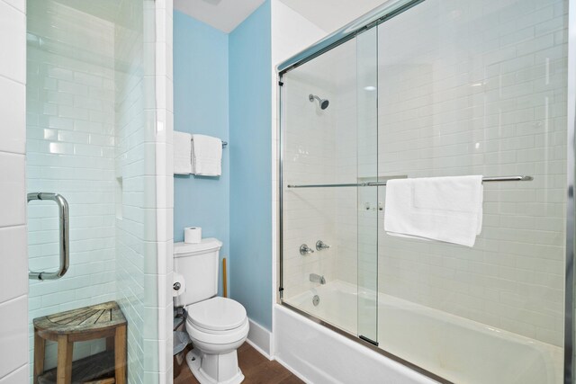 bathroom with shower / bath combination with glass door, toilet, and wood-type flooring