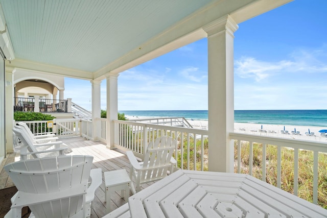 balcony featuring a water view and a beach view