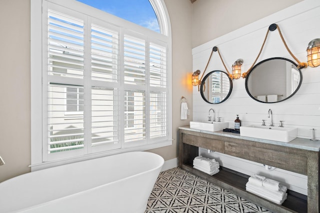 bathroom featuring a tub to relax in, plenty of natural light, and vanity