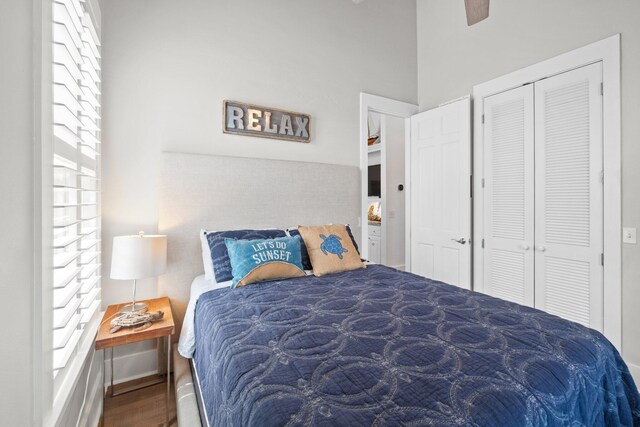 bedroom featuring dark wood-type flooring, ceiling fan, and a closet