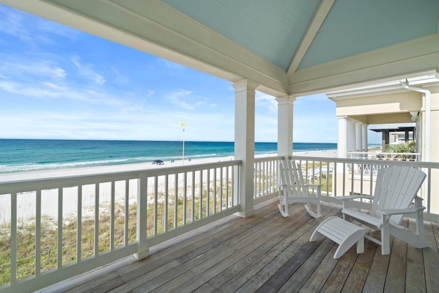 wooden terrace featuring a water view and a view of the beach