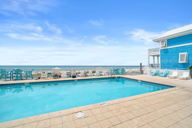 view of swimming pool with a water view and a patio area