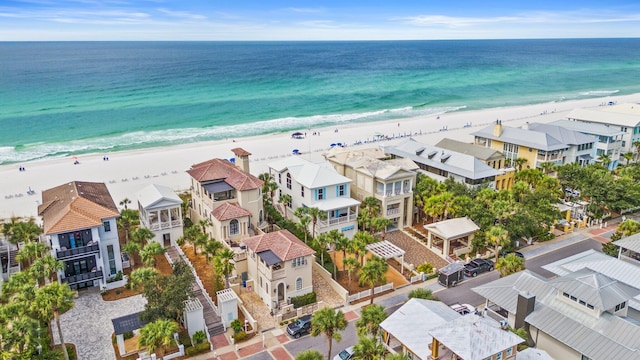 drone / aerial view featuring a beach view and a water view