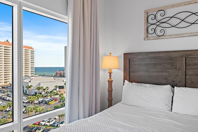 bedroom with multiple windows and a water view