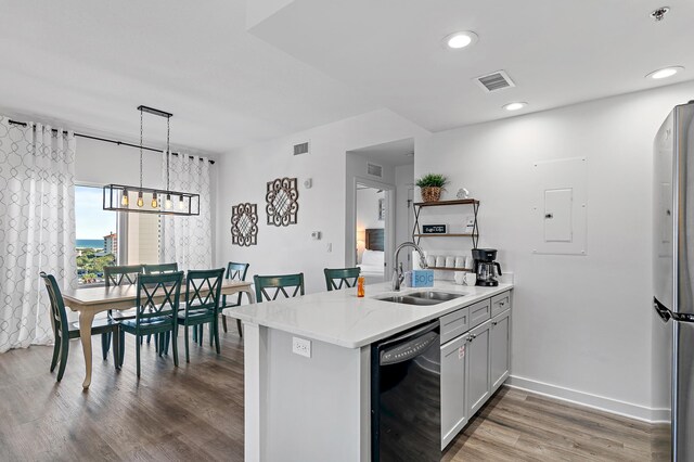 kitchen with dishwasher, sink, kitchen peninsula, decorative light fixtures, and stainless steel fridge