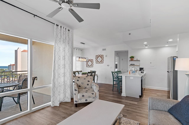 living room with sink, dark wood-type flooring, and ceiling fan