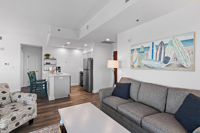 living room with dark hardwood / wood-style floors and sink