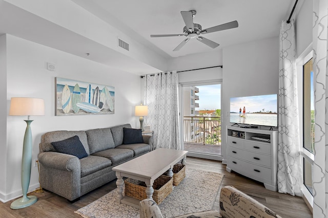 living room featuring ceiling fan and dark hardwood / wood-style floors