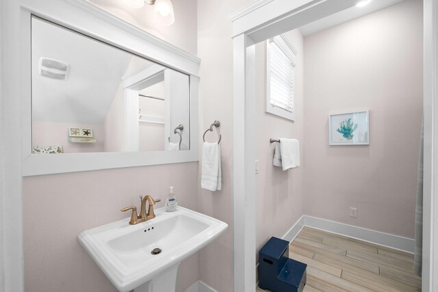 bathroom featuring vaulted ceiling, hardwood / wood-style floors, and sink