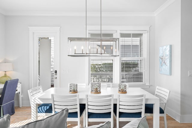 dining space featuring light wood-type flooring and crown molding